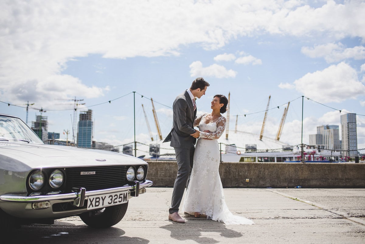 Bride and groom portrait at Trinity Buoy wharf with classic car